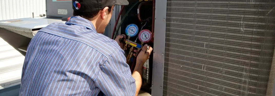 HVAC technician servicing a condenser unit in Verde Village