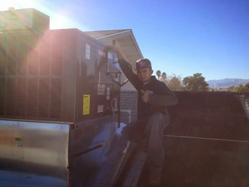 HVAC technician performing Heat Pump Repair on a rooftop unit in Verde Village